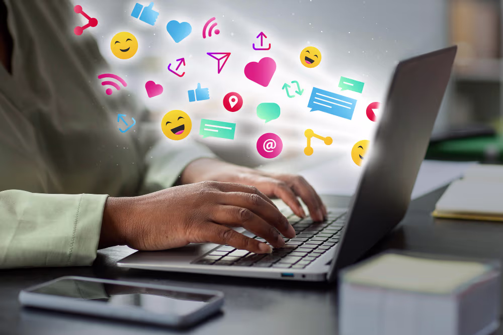 fingers typing on a laptop with social media icons symbolizing the effectiveness of Asomah Digital's hotel marketing trainings.